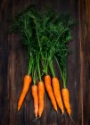 Bouquet de carottes fraîches sur fond en bois — Photo de stock