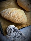 Две свежеиспеченные буханки хлеба на хлебном листе — стоковое фото