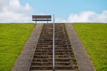 Bench on a dyke at the top of a staircase, East Frisia, Lower Saxony, Germany — Stock Photo
