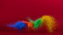 Multi coloured sand flying through the air — Stock Photo