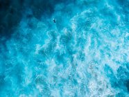 Вид с воздуха на серфера, лежащего на доске для серфинга в океане, Госфорд, Новый Южный Уэльс, Австралия — стоковое фото