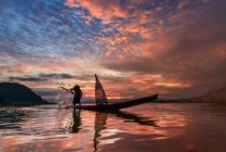 Silhouette di un pescatore che pesca in un fiume, Thailandia — Foto stock
