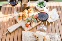 Антипасто і червоне вино на столі на відкритому повітрі — стокове фото