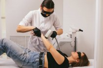 Женщина, проходящая процедуру лазерной эпиляции в салоне красоты — стоковое фото
