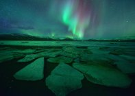 Luces boreales sobre la playa de Diamond y Jokulsarlon por la noche, Islandia central del sur, Islandia - foto de stock