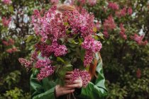Жінка стоїть на відкритому повітрі тримає свіжо підібрані квіти — стокове фото