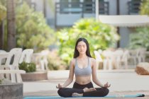 Schöne Frau sitzt in Lotus-Pose und meditiert, Thailand — Stockfoto