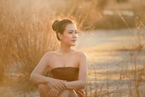 Женщина, сидящая на пляже, Таиланд — стоковое фото