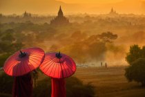 Vista posteriore di due monaci novizi con ombrelloni che guardano in vista, Bayan, Mandalay, Myanmar — Foto stock