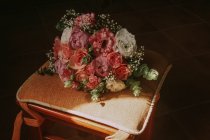 Свадебный букет на стуле под солнцем — стоковое фото