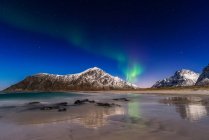 Luces boreales sobre montañas costeras, Lofoten, Nordland, Noruega - foto de stock