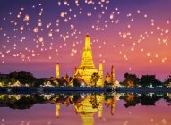 Wat Arun Temple Complex with Chinese lanterns in the sky at sunset, Bangkok, Thailand — Stock Photo