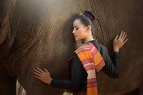 Belle femme caressant un éléphant, Thaïlande — Photo de stock