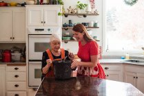 Старшая женщина учит свою дочь печь хлеб — стоковое фото