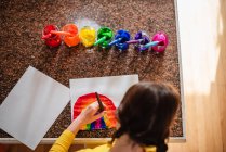 Дівчина сидить на кухні малює веселку — стокове фото