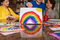 Drei Kinder sitzen in der Küche und malen einen Regenbogen — Stockfoto