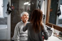 Девушка наносит макияж на свою бабушку — стоковое фото
