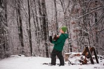 Junge sammelt Brennholz von einem Holzstapel im Garten, USA — Stockfoto