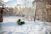Boy sledding down a hill in the snow, EUA — Fotografia de Stock