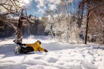 Junge schlittert im Schnee einen Hügel hinunter, USA — Stockfoto