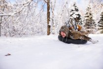 Man tubing down a hill in the snow, Estados Unidos - foto de stock