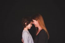Retrato de una madre de pie cara a cara con su hijo - foto de stock
