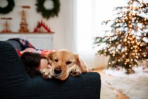 Mädchen schläft auf einem Sofa mit ihrem Hund — Stockfoto
