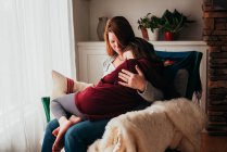 Girl sitting on her mother's lap — Stock Photo