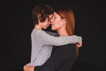 Retrato de una madre abrazando a su hijo - foto de stock
