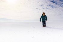 Хлопчик прогулюючись сніжним полем, США. — стокове фото