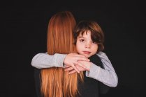 Visão traseira de uma mulher abraçando seu filho — Fotografia de Stock