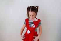 Chica sosteniendo una decoración en forma de corazón a través de su pecho - foto de stock