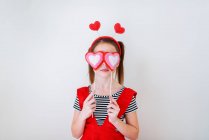 Menina com cabeça em forma de coração segurando decorações do coração — Fotografia de Stock