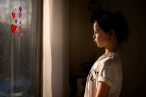 Mädchen blickt durch ein Fenster — Stockfoto
