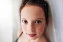Portrait d'une jeune fille maquillée debout près d'un rideau — Photo de stock