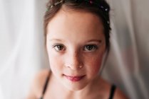 Retrato de una chica joven con maquillaje de pie junto a una cortina - foto de stock