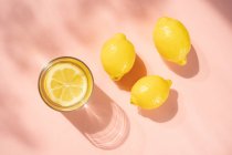 Copo de água de limão com limões — Fotografia de Stock