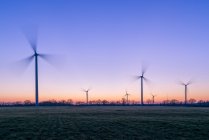 Silhouette delle turbine eoliche al tramonto, Francia — Foto stock