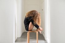 Mulher bonita sentada em uma cadeira em seu corredor — Fotografia de Stock