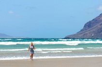 Beautiful woman in a summer dress on Famara beach, Lanzarote, Canary Islands, Spain — Stock Photo