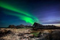 Luces boreales sobre paisaje montañoso costero, Lofoten, Nordland, Noruega - foto de stock