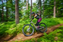 Donna mountain bike attraverso la foresta, Klagenfurt, Carinzia, Austria — Foto stock