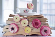 Tasse de thé sur une pile de livres et de fleurs — Photo de stock
