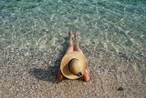 Vue arrière d'une femme allongée dans le surf, île Krk, Stara Baska, Croatie — Photo de stock