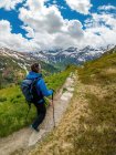 Junge Frau wandert auf Fußweg in den österreichischen Alpen bei Gastein, Salzburg — Stockfoto