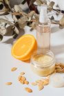 Lip balm and moisturisers with argan seeds, orange and dried leaves — Stock Photo