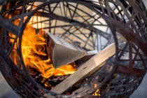 Gros plan sur la combustion de bois dans une cheminée circulaire extérieure, Suisse — Photo de stock