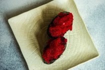 Visão aérea de dois tobiko nigiri sushi em uma placa de cerâmica — Fotografia de Stock