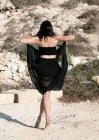 Vista trasera de una bailarina al aire libre sosteniendo el dobladillo de su vestido bailando, Malta - foto de stock