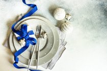 Boîte cadeau enveloppée attachée avec un ruban bleu et des boules de Noël — Photo de stock